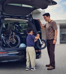 Father and son loading bicycles into a car